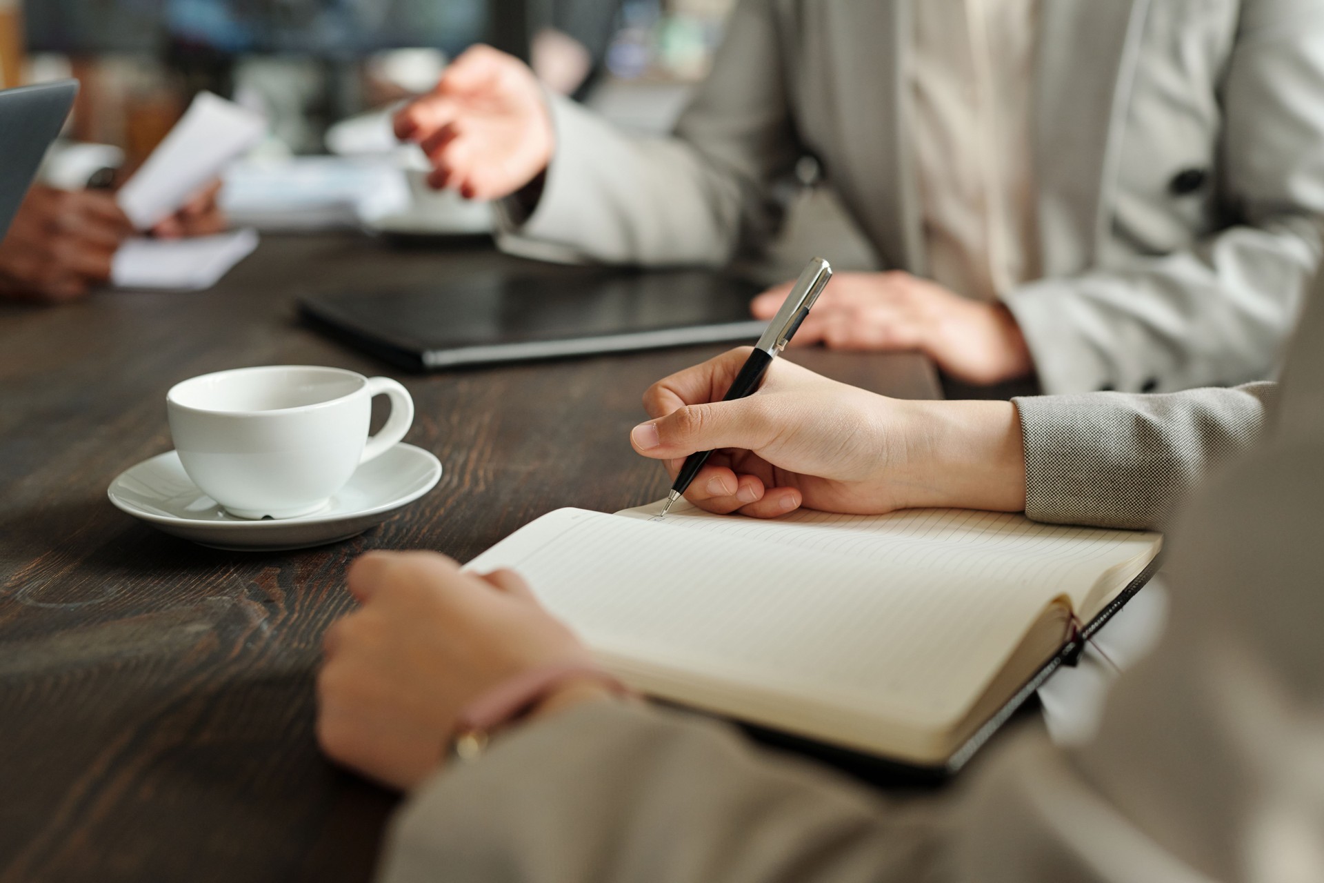 Caucasian Young Adult Woman Writing Notes during Business Meeting Top View