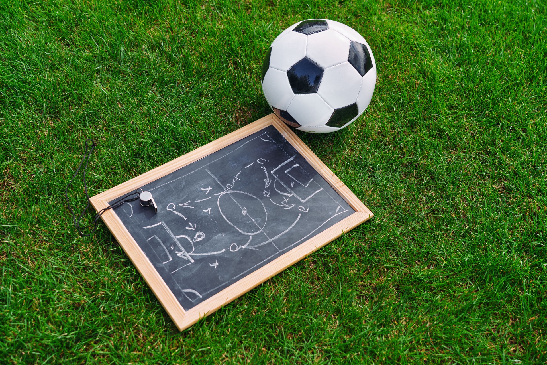 Tactic plan, soccer ball and referee whistle. Hand drawn strategy scheme sketch, isolated on on the black chalkboard.