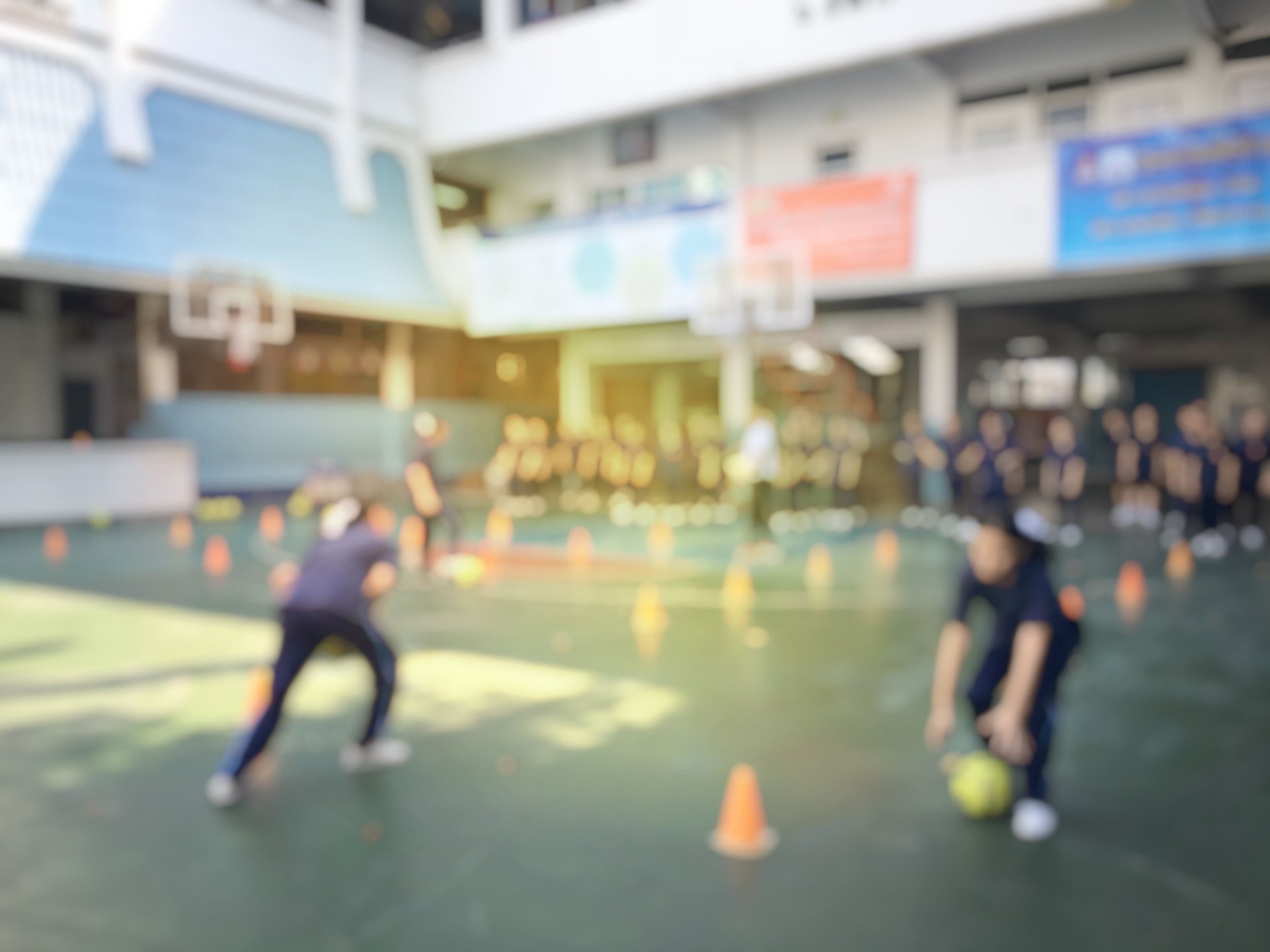 Blurred image of children or male and female students in secondary school are learning football or soccer on school playground in physical education time. Bangkok,Thailand. physical activities concept